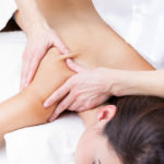 Pretty Woman enjoying shoulder massage at beauty spa